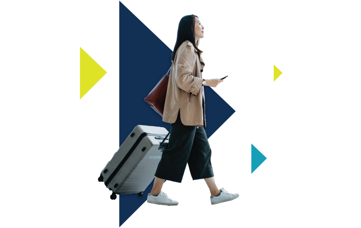 A woman walks with a suitcase trailing behind her.